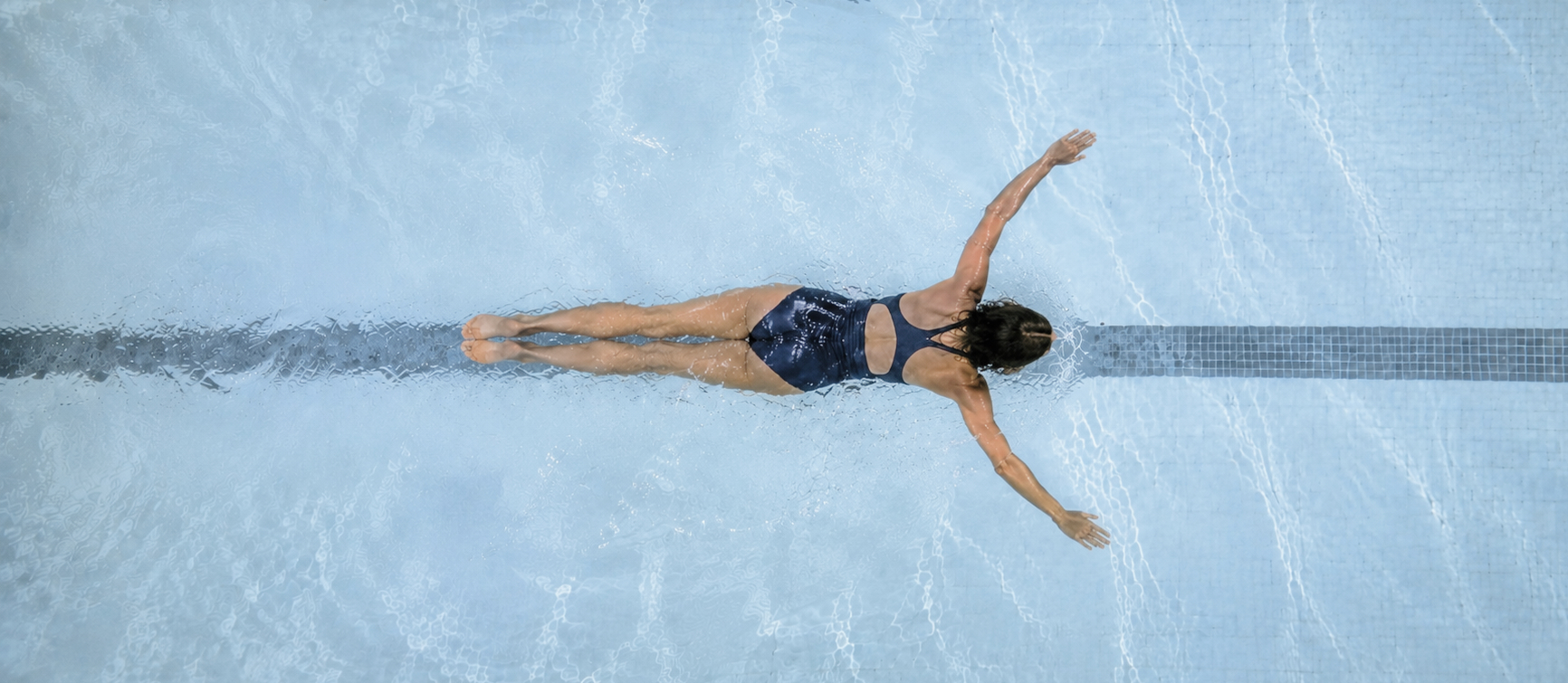 A swimmer floating peacefully on her back in still open water